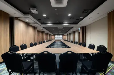 a conference room with a long table and chairs at Golden Tulip Krakow Kazimierz in Kraków