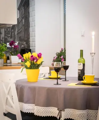 a table with two glasses of wine and flowers on it at Cracowapart Loft Gertruda in Kraków