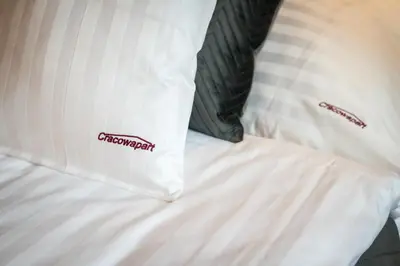 a white pillow on a bed with a comforter at Cracowapart Loft Gertruda in Kraków