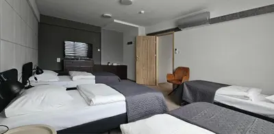 a hotel room with four beds and a television at Hotel Great Polonia Kraków Airport in Modlniczka