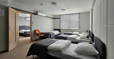 a room with three beds and a window at Hotel Great Polonia Kraków Airport in Modlniczka