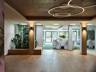 a banquet hall with white tables and white chairs at Hotel Great Polonia Kraków Airport in Modlniczka