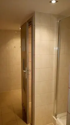 a bathroom with a shower and a door at Hostel Bazar in Kraków