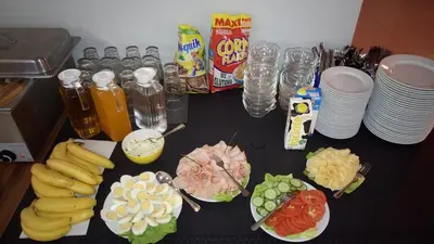 a table with bananas and plates of food and drinks at Hostel Bazar in Kraków