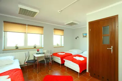 a hotel room with two beds and a table and a tableablish at Hostel Bazar in Kraków