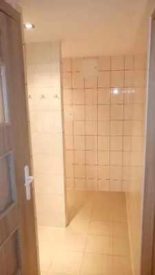 a bathroom with a shower with a tiled floor at Hostel Bazar in Kraków