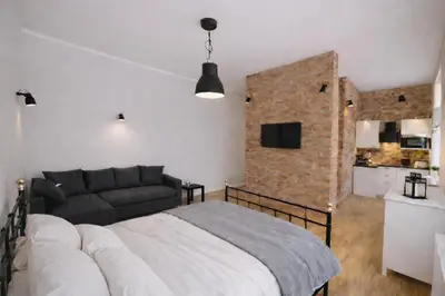 a room with a bed and a brick wall at Elpida Apartment in Kraków