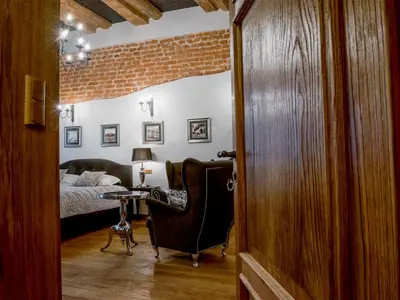 a bedroom with a bed and a table and a chair at Leonardo 2 in Kraków
