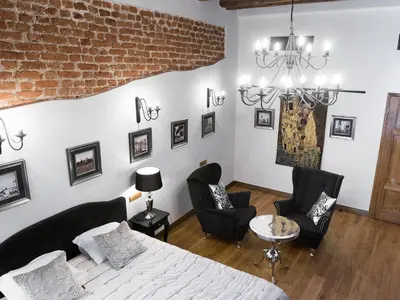 a living room with a bed and two chairs at Leonardo 2 in Kraków