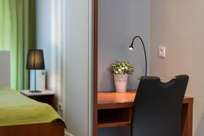 a bedroom with a desk with a lamp and a chair at River Boulevards Apartment in Kraków