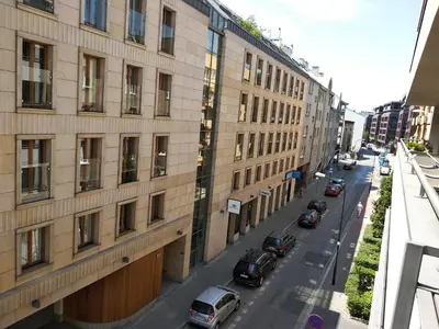 a city street with cars parked next to a building at River Boulevards Apartment in Kraków