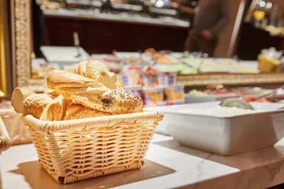 a basket of bread on a table with a bowl of food at Pollera in Kraków
