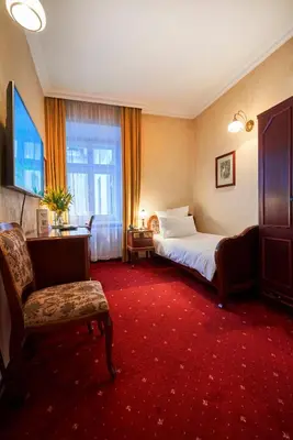 a hotel room with a bed and a chair at Pollera in Kraków