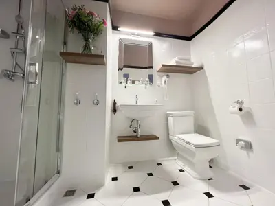 a white bathroom with a sink and a toilet at Pollera in Kraków