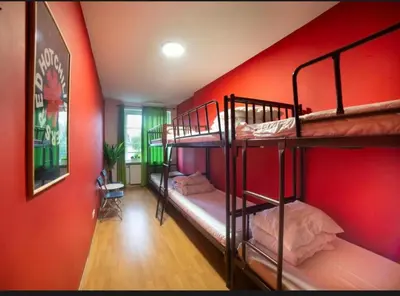 two bunk beds in a room with red walls at Let's Rock Party Hostel! Age Limit From 18 until 40! in Kraków
