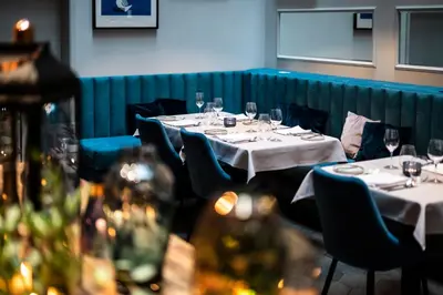a dining room with tables and chairs with wine glasses at Hotel Indigo Krakow - Old Town by IHG in Kraków