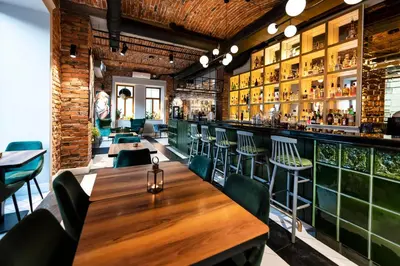 a restaurant with tables and chairs and a brick wall at Hotel Indigo Krakow - Old Town by IHG in Kraków