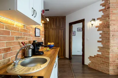a kitchen with a sink and a brick wall at Passion4Cracow in Kraków