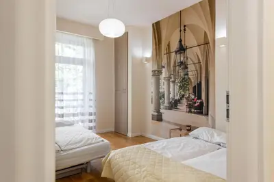 a bedroom with two beds and a window at Królewska Apartments in Kraków