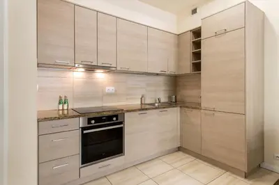 a kitchen with wooden cabinets and a stove at Królewska Apartments in Kraków
