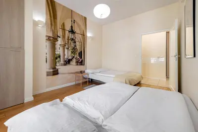 a bedroom with two beds and a hallway at Królewska Apartments in Kraków