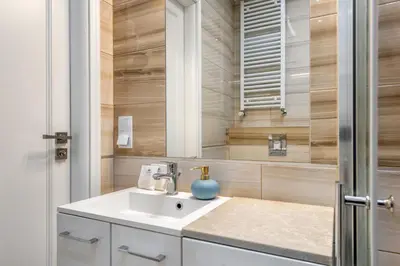a bathroom with a sink and a mirror at Królewska Apartments in Kraków