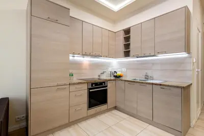 a kitchen with wooden cabinets and a sink at Królewska Apartments in Kraków