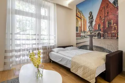 a bedroom with a bed and a painting on the wall at Królewska Apartments in Kraków