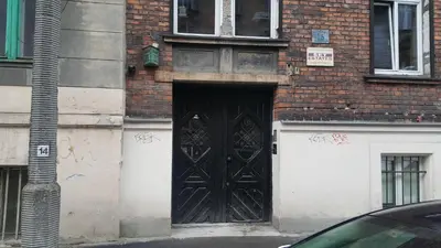 a brick building with a large black door on it at Pokoje Gościnne Centrum in Kraków