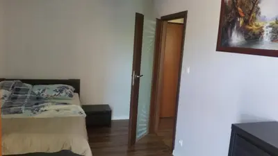 a bedroom with a bed and a mirror next to a door at Apartament Wilga Park in Kraków