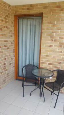 a patio with a table and chairs and a window at Apartament Wilga Park in Kraków