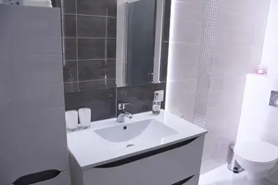 a white bathroom with a sink and a toilet at Apartament Wilga Park in Kraków