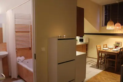 a small kitchen with a refrigerator and a table at 4Party in Kraków