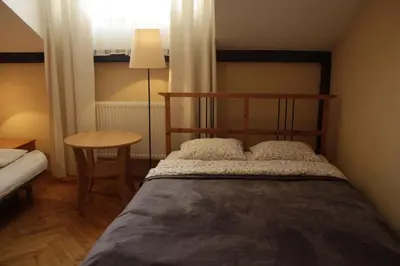 a bedroom with a bed and a table and a window at 4Party in Kraków