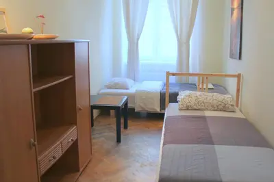 a small bedroom with two beds and a window at 4Party in Kraków