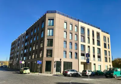 a large building with cars parked in front of it at Kraków Apartments - Solna Studio & Apartments in Kraków
