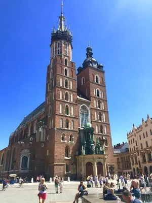 a large building with two towers with people in front of it at Kraków Apartments - Solna Studio & Apartments in Kraków