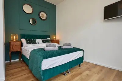 a green bedroom with a bed and a television at NOOK NOOK Apartments Katarzyny 2 in Kraków