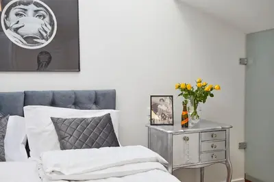 a bedroom with a bed and a table with a vase of flowers at NOOK NOOK Apartments Katarzyny 2 in Kraków