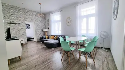 a living room with a table and green chairs at NOOK NOOK Apartments Katarzyny 2 in Kraków