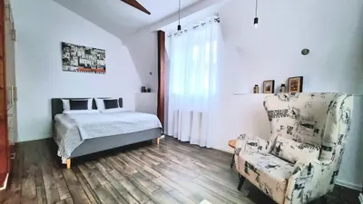 a bedroom with a bed and a chair at NOOK NOOK Apartments Katarzyny 2 in Kraków
