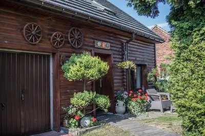 a wooden house with flowers in front of it at Apartamenty na Kasztelańskiej in Spytkowice