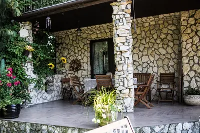 a patio with chairs and a stone wall at Apartamenty na Kasztelańskiej in Spytkowice