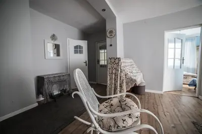 a white room with a chair and a fireplace at Apartamenty na Kasztelańskiej in Spytkowice