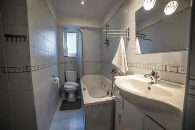 a bathroom with a sink and a toilet and a tub at Apartamenty na Kasztelańskiej in Spytkowice