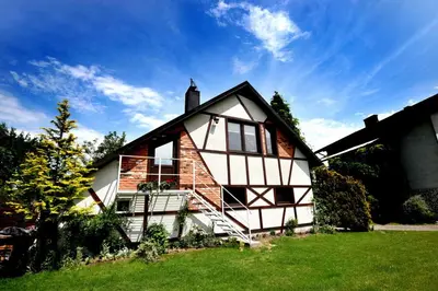 a white and brown house with a green lawn at Apartamenty na Kasztelańskiej in Spytkowice