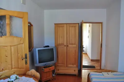 a living room with a television and a door to a hallway at Agroturystyka Zagroda in Podobin