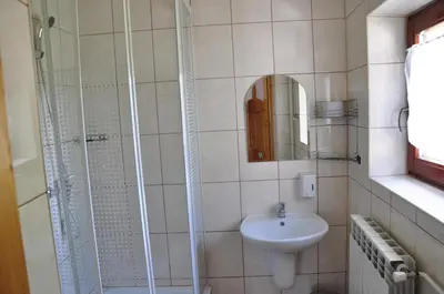 a bathroom with a shower and a sink and a sink at Agroturystyka Zagroda in Podobin