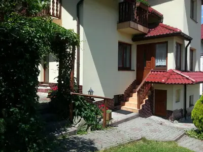 a house with a gate and a balcony at Agroturystyka Zagroda in Podobin