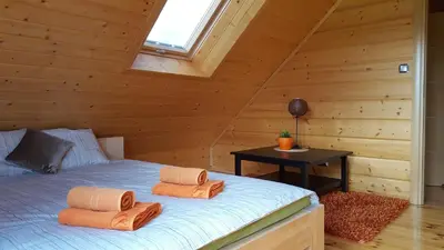 a bedroom with a bed in a wooden cabin at Beskidzka Chata in Hucisko